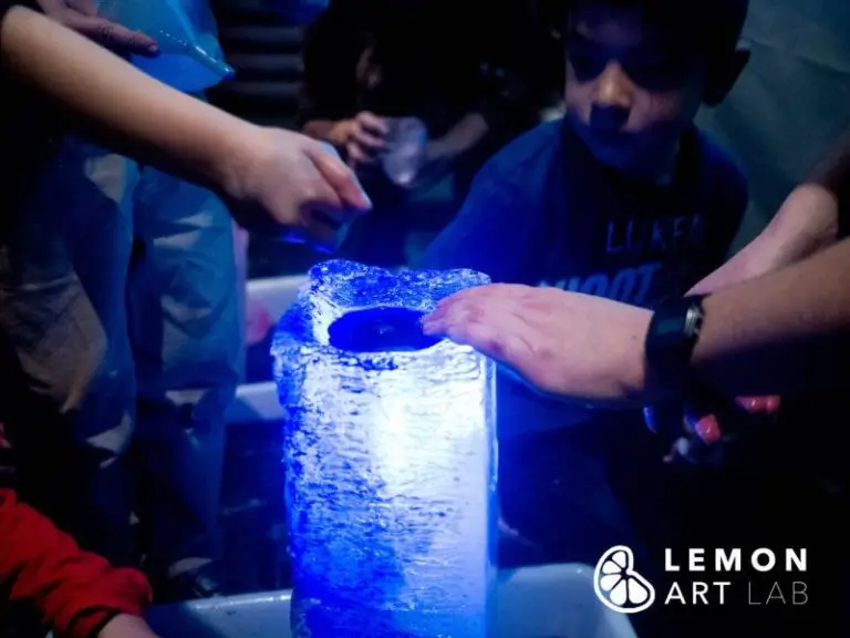 Niños tocan una escultura de hielo