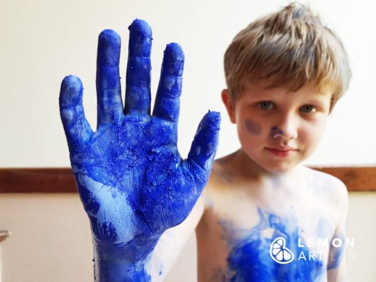 Niño jugando con pigmento azul Klein
