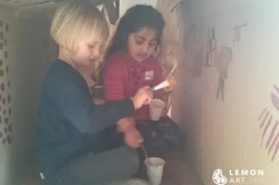 Niños hacen arte prehistórica en una instalación de juego