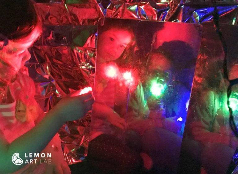 Niños exploran una instalación artística con reflejos