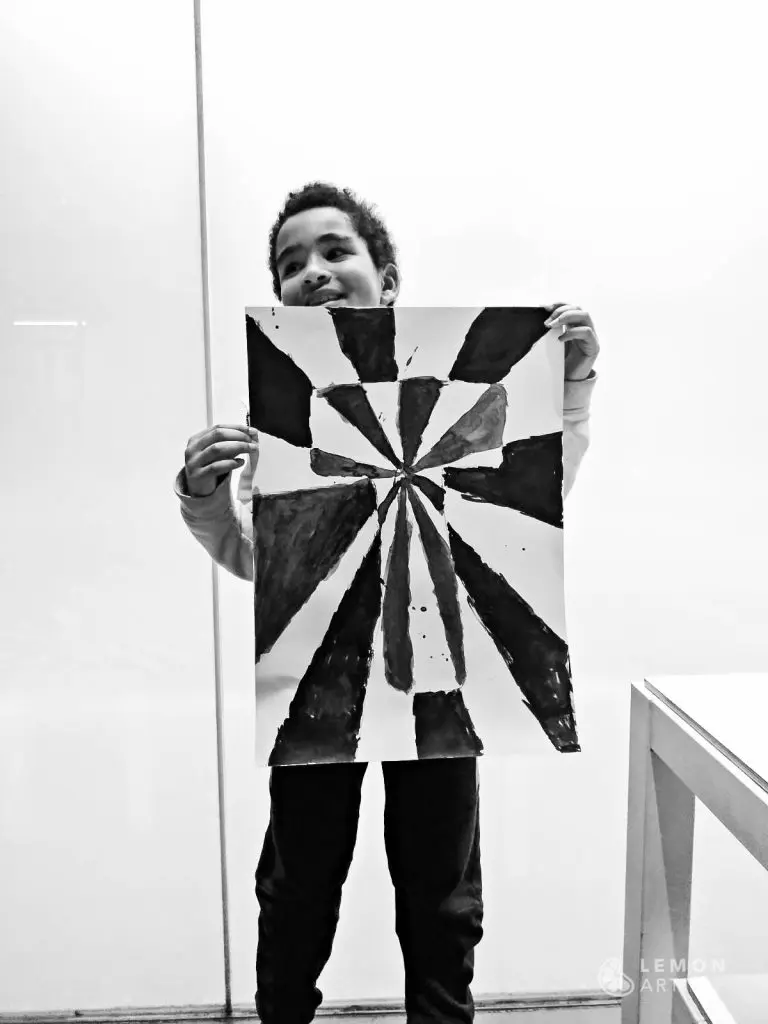 Niño muestra su pintura óptica