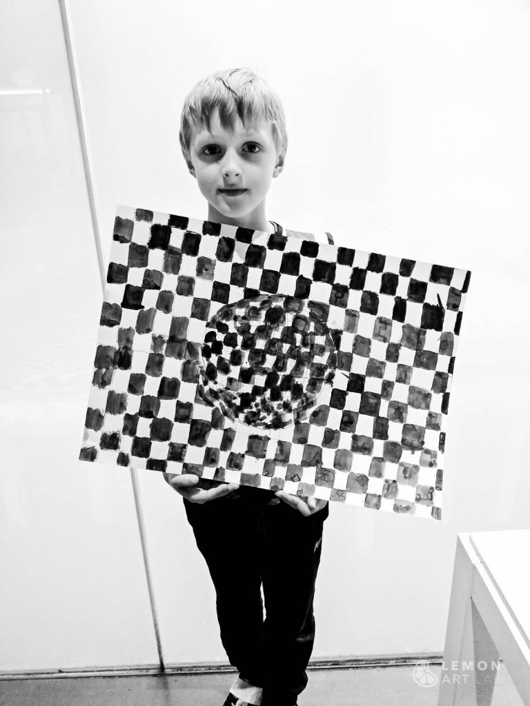 Niño muestra su pintura de patrones matemáticos