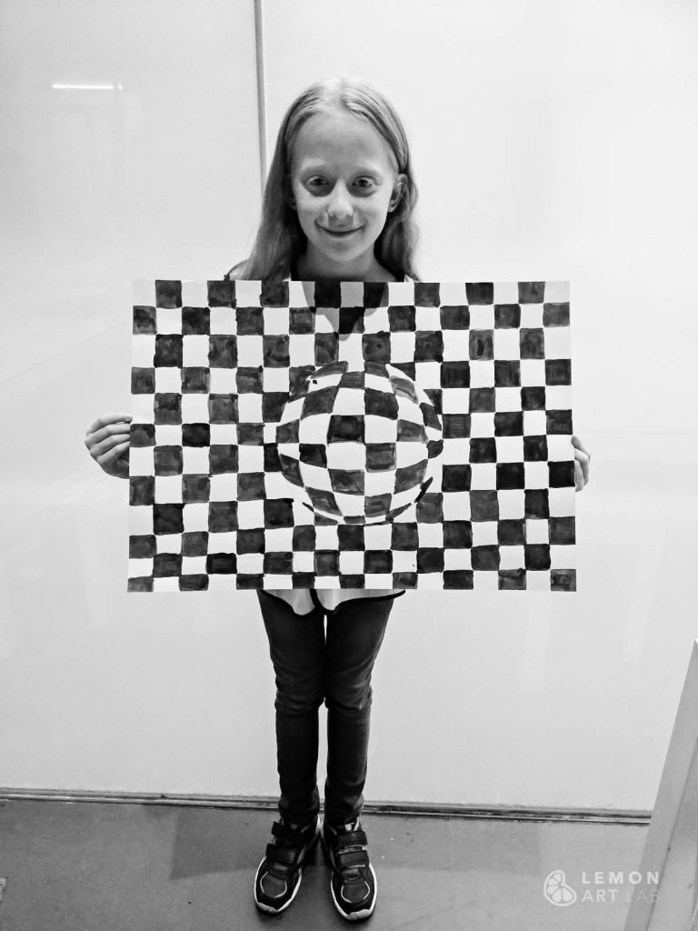 Niña muestra su obra de arte óptico