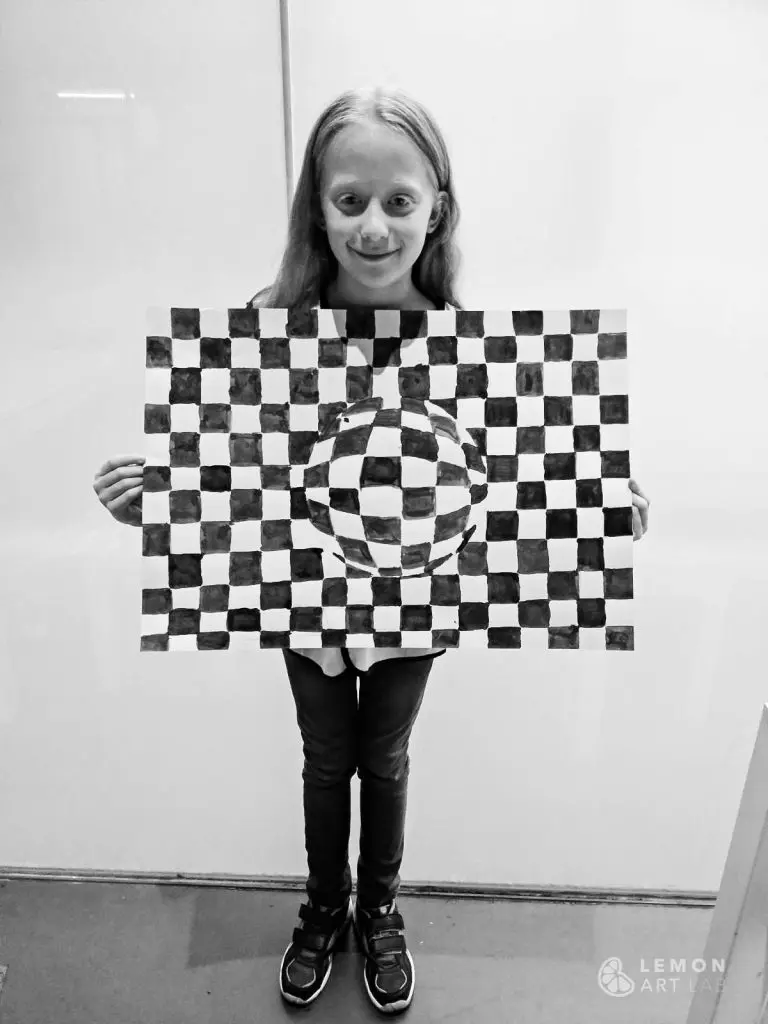 Niña muestra su obra de arte óptico