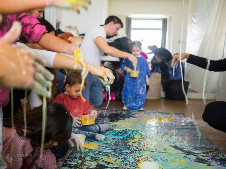 Familias crean un mural de pintura de acción