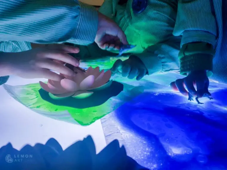 Niños de preescolar juegan con nenúfares y mesas de luz