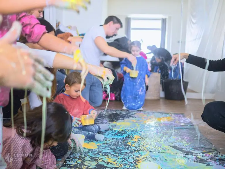 Familias creando un mural con pintura sensorial