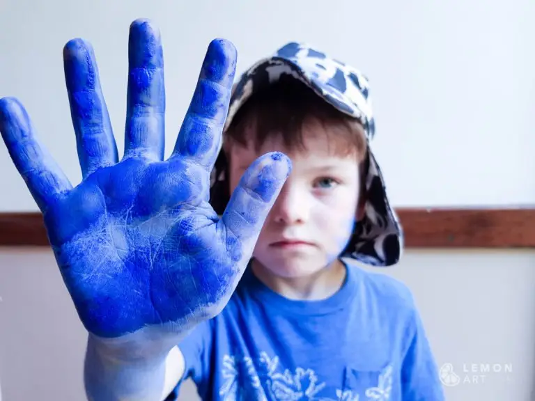 Niño con pigmento azul klein en su mano