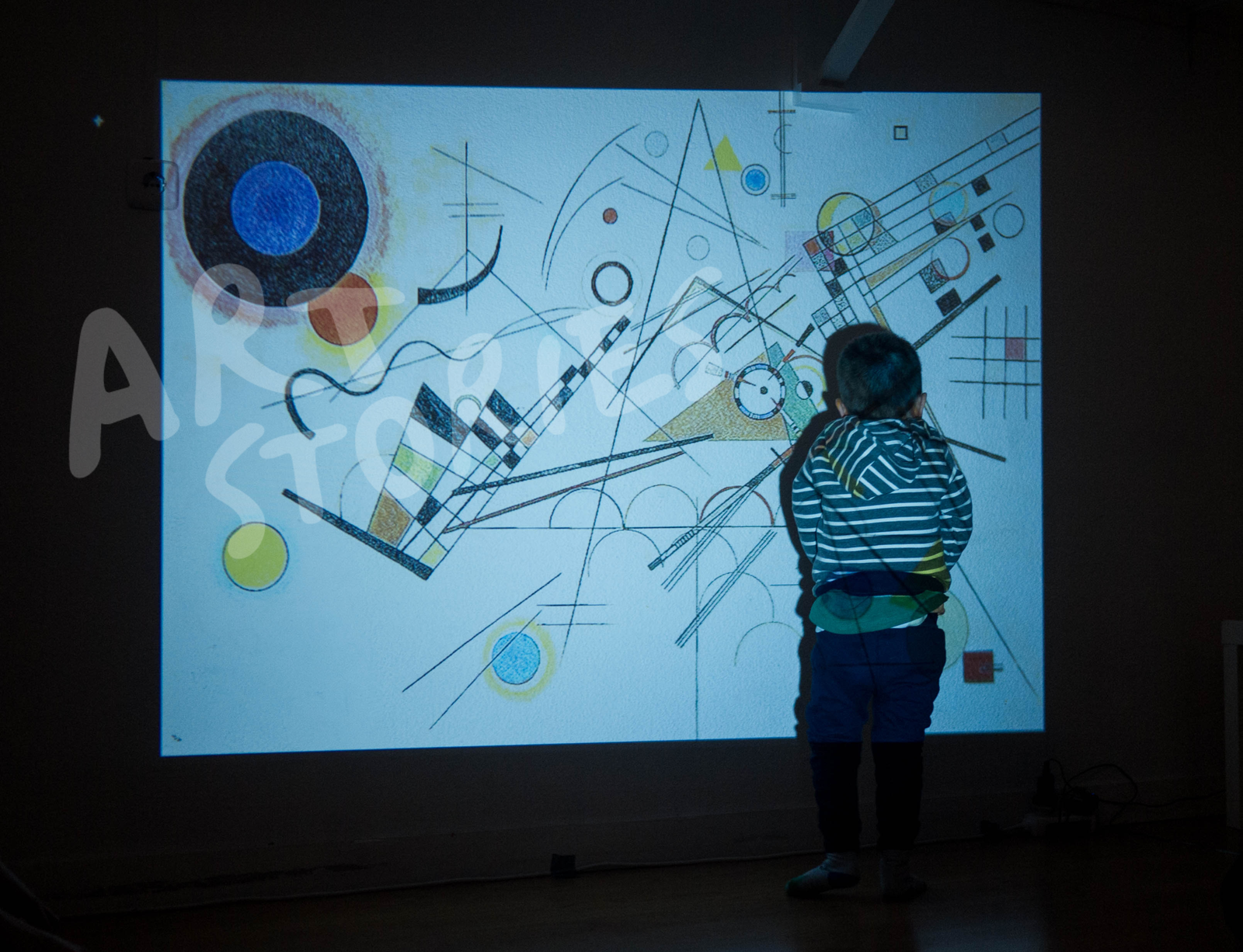 Niño con una videoproyección de arte abstracto